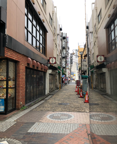 路地を入ると左手にたばこ屋さん、右手奥は「登良屋」さま、「野毛おでん」さまの看板が見えます。